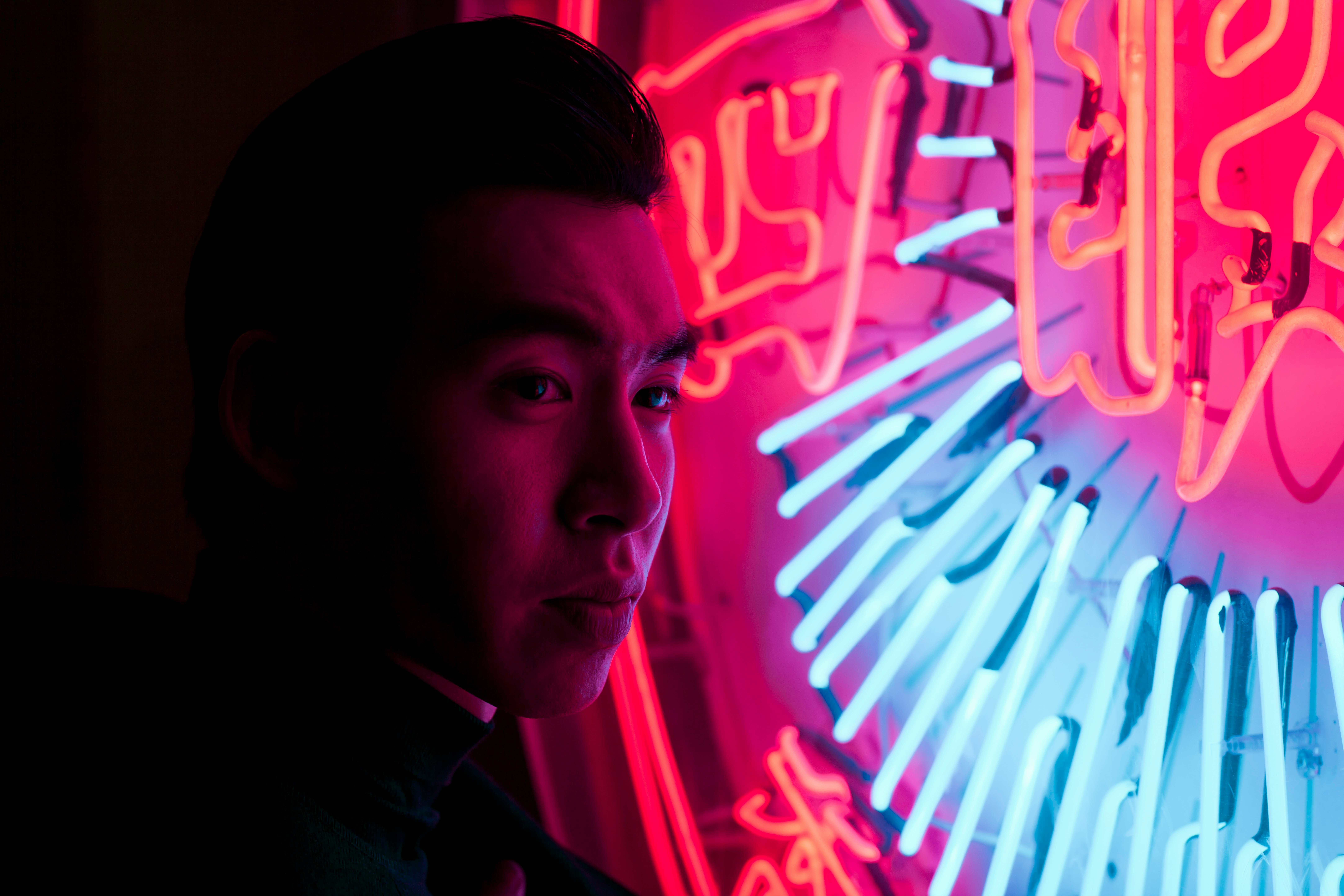 man standing near neon signage light
